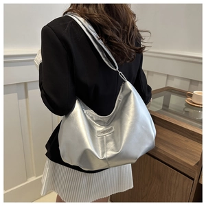 Détail du sac cabas plissé argenté avec étiquette tendance sur tenue décontractée