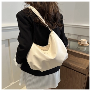 Détail d'un grand sac Hobo blanc crème montrant le cuir souple et le logo de mode