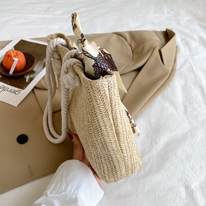Detail of hand-woven straw tote with cotton rope handles and colorful silk scarf decoration