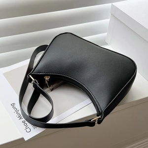 Dettaglio della borsa a spalla in pelle nera opaca con zip dorata e texture