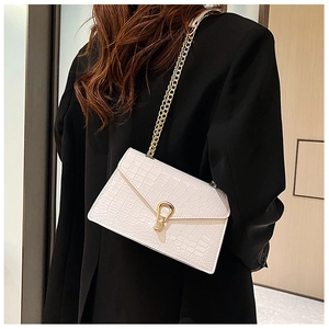 Close-up of beige crocodile pattern envelope bag with gold chain and unique metal buckle