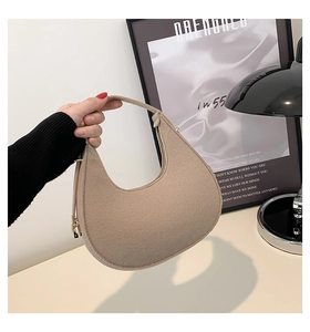 Dettaglio della borsa hobo in feltro beige con cerniera metallica e consistenza morbida moderna