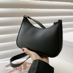 Dettaglio della borsa hobo nera con trama in pelle opaca e finiture metalliche dorate