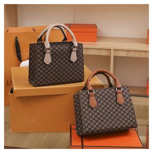 Detail showing two vintage plaid tote bags with gold rings and contrasting handles