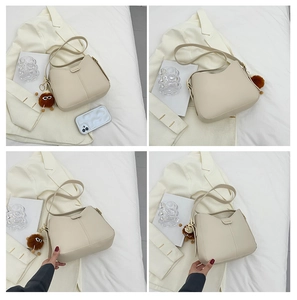 Dettaglio della borsa a spalla crema minimalista con fibbia FASHION e ciondolo peloso