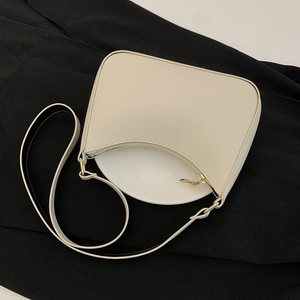Dettaglio della borsa sottobraccio in pelle PU bianco crema con texture liscia e zip dorata