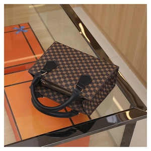 Detailed view of the dark brown retro tote bag with circular geometric print and gold zipper