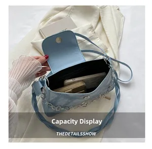 Détail de l'intérieur du sac à bandoulière matelassé avec téléphone et portefeuille