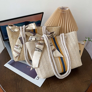 Detail of colorful striped straw tote bag set with rope handles and decorative scarves