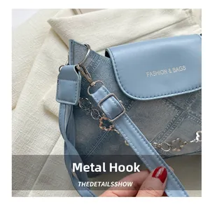 Détail du sac matelassé bleu clair avec ferrures argentées et breloque fleurie élégante