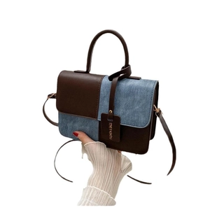 Sac à bandoulière bicolore en cuir marron et denim bleu avec poignée supérieure élégante