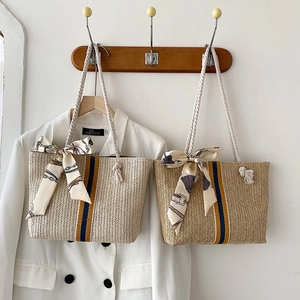 Detail of straw woven tote with colorful vertical stripes and soft cotton rope handle