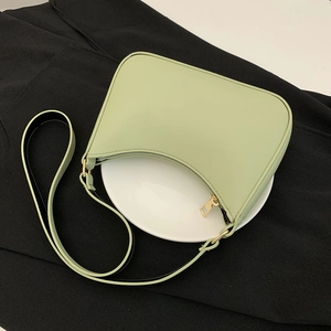 Dettaglio borsa sottobraccio verde menta con cerniera dorata su espositore bianco