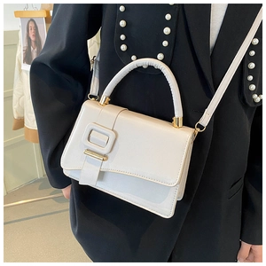 Borsa a tracolla in pelle bianca con fibbia quadrata indossata da modella in blazer nero