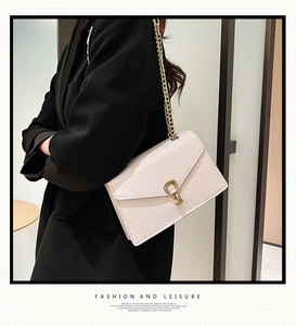 Crocodile pattern chain bag in creamy white with gold buckle shown on a model