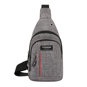 Gray crossbody sling bag with headphone jack and multiple zippered compartments for travel