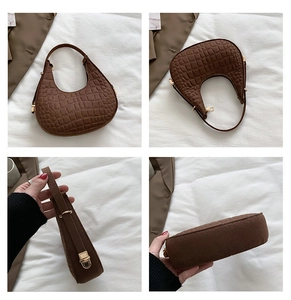 Detail view of brown crocodile pattern hobo bag with gold hardware and curved structure