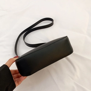 Dettaglio della texture in pelle opaca e delle cuciture sulla borsa a tracolla nera