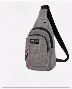 Detail view of grey canvas crossbody chest bag featuring a built-in headphone jack and earphone port