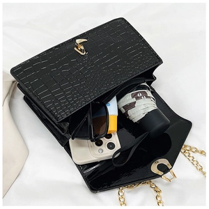 Interior view of crocodile pattern crossbody bag showing capacity for phone and sunglasses