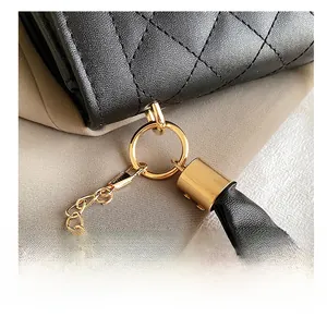 Detail of high-quality gold metal hook and black quilted leather strap with chain
