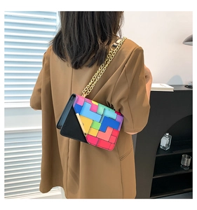 Detail of crossbody bag with colorful geometric patterns and gold triangular hardware