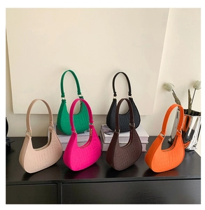 Close-up of six colorful faux crocodile skin hobo bags with textured PU leather finish