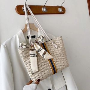 Detail of straw tote bag featuring blue yellow stripes and cotton rope handles