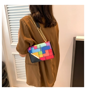 Detail of colorful geometric block pattern mini bag with golden chain strap