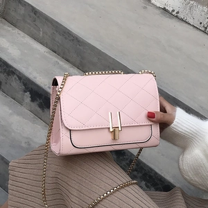 Detail of pink quilted PU leather bag with golden chain strap and rectangular metal lock