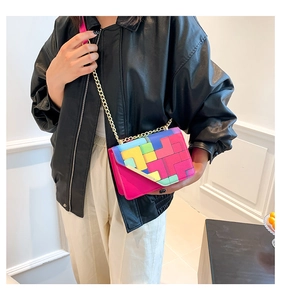 Detail of vibrant geometric patchwork chain bag worn by model in a black leather jacket