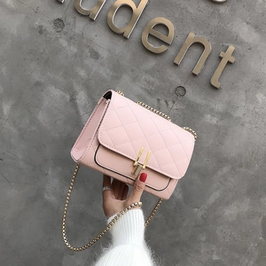 Close-up of pink quilted crossbody bag with gold chain strap and metal lock