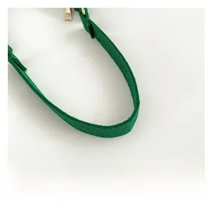 Detail view of the green felt shoulder bag showing comfortable handle and gold metal buckle