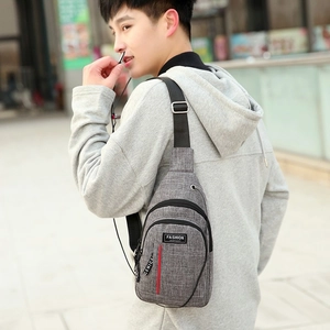 Gray Oxford fabric chest bag shown on model back with adjustable strap and headphone port