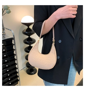 Dettaglio borsa beige in ecopelle coccodrillo con fibbie dorate e tracolla singola