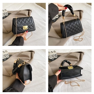 Detail of black quilted shoulder bag featuring gold chain and ruched handle texture