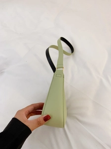 Dettaglio della borsa sottobraccio verde chiaro con cuciture laterali e tracolla