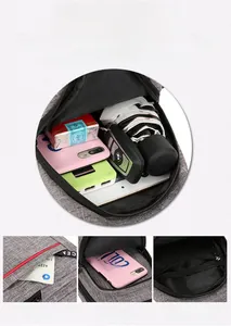Detail view of multifunctional grey sling bag showing internal storage for iPad and umbrella