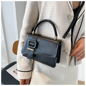 Dettaglio di una borsa in pelle nera chic con fibbia dorata e finitura testurizzata
