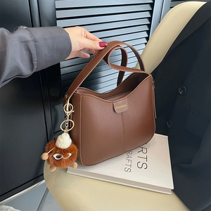 Borsa a secchiello a tracolla in pelle marrone con scritta fashion e ciondolo di peluche