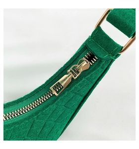 Detail view of emerald green felt bag featuring metal zipper and high-quality d-ring hardware