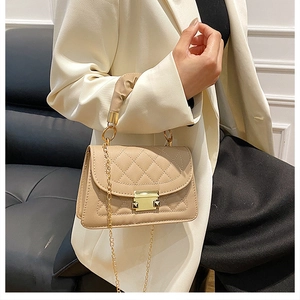 Detail of apricot quilted flap bag with gold metal buckle and chain strap