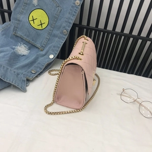 Detail view of pink quilted handbag featuring gold metal chain and chic diamond stitching