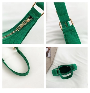 Detailed close-up of bright green felt shoulder bag showing golden zipper and metal hardware