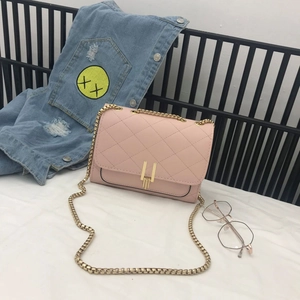 Close-up of pink quilted crossbody bag featuring a gold chain strap and metal clasp