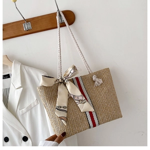 Detail of colorful striped woven tote bag with cotton rope handle and decorative silk scarf