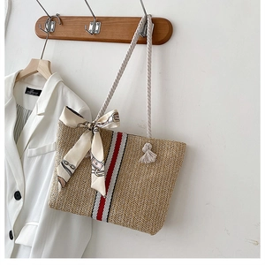 Detail of hand-woven straw tote with red stripes and white cotton rope handle