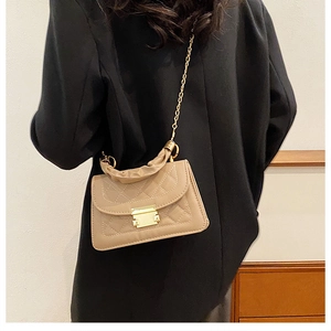 Detail view of a quilted milk tea crossbody bag with gold chain and ruched handle