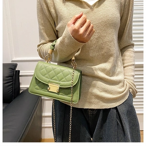 Close-up of green quilted shoulder bag with gold chain strap and stylish handle