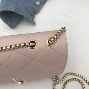 Close-up of pink quilted leather bag with golden chain strap and premium metal hardware